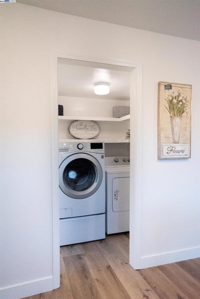 washroom featuring washer and dryer and light hardwood / wood-style floors