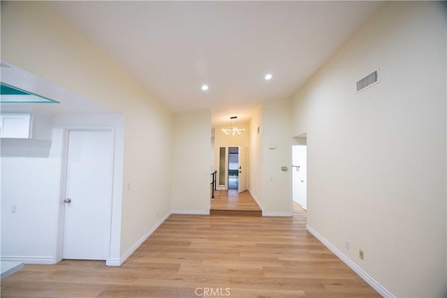 hallway featuring light hardwood / wood-style flooring and a notable chandelier