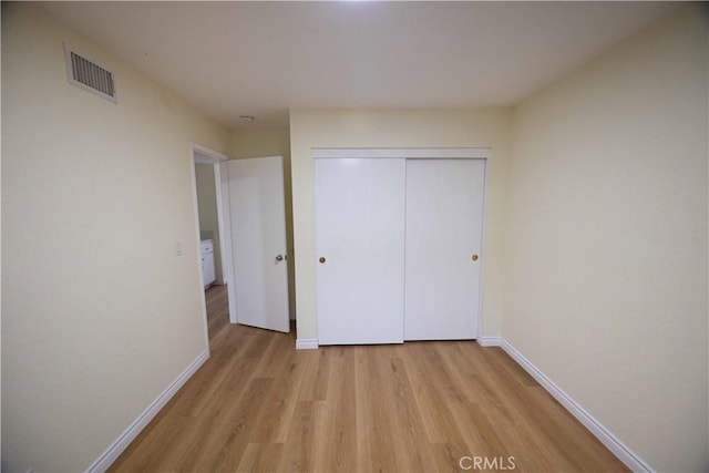 unfurnished bedroom featuring a closet and light hardwood / wood-style floors