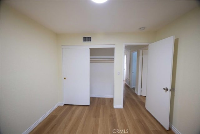 unfurnished bedroom with a closet and light hardwood / wood-style flooring