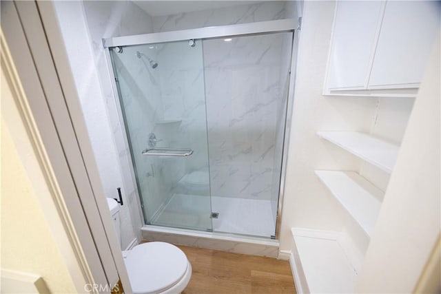 bathroom featuring toilet, hardwood / wood-style flooring, and an enclosed shower