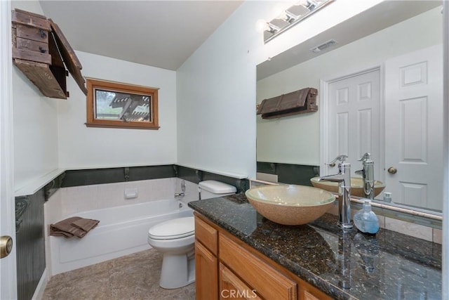 bathroom with a tub to relax in, toilet, and vanity