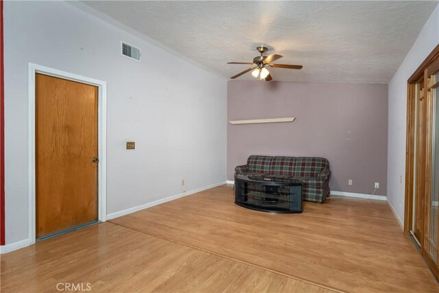 unfurnished room with ceiling fan, hardwood / wood-style flooring, vaulted ceiling, and a textured ceiling