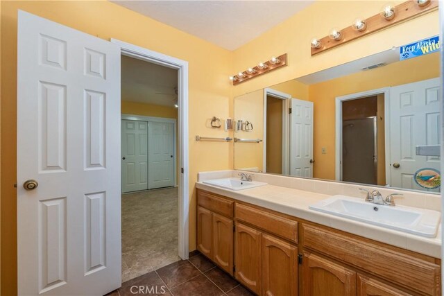 bathroom with vanity, a shower with shower door, and tile patterned flooring