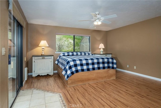 bedroom featuring radiator heating unit, ceiling fan, and light wood-type flooring