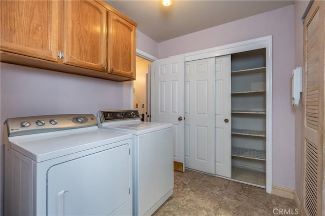 washroom with cabinets and washing machine and dryer