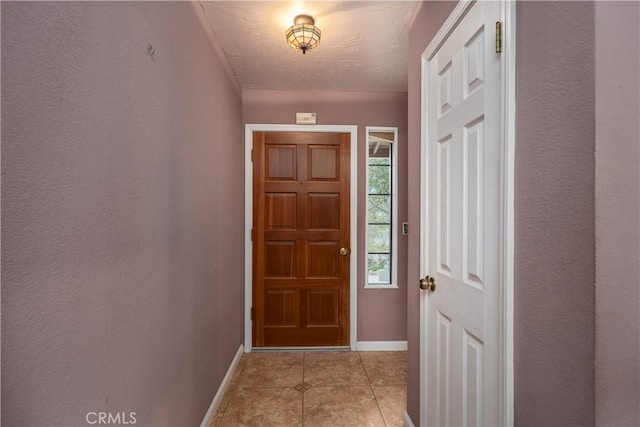 doorway to outside with light tile patterned flooring and a textured ceiling