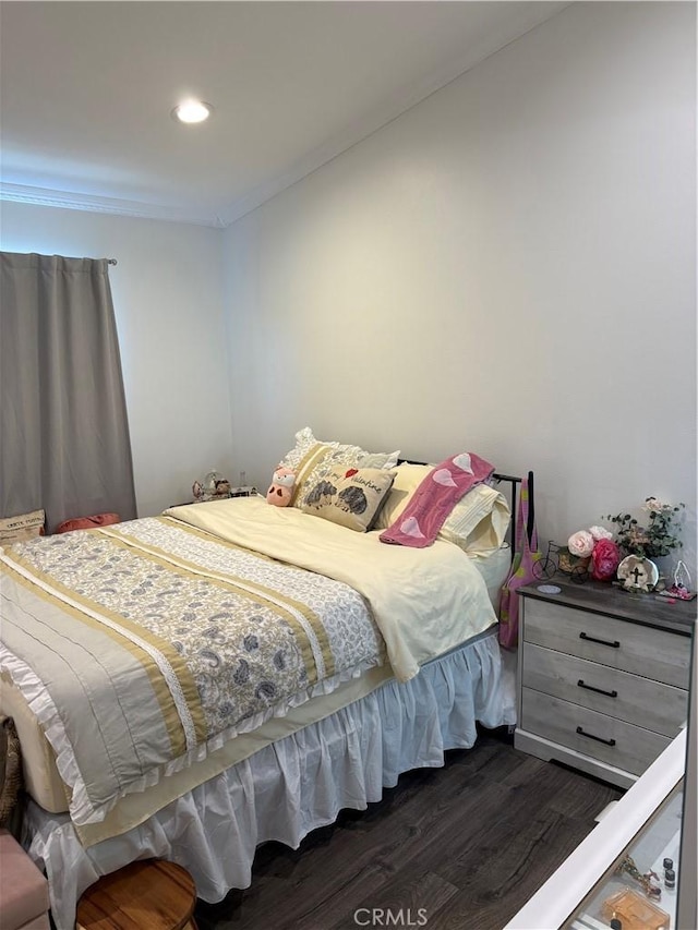 bedroom featuring crown molding and dark wood-type flooring