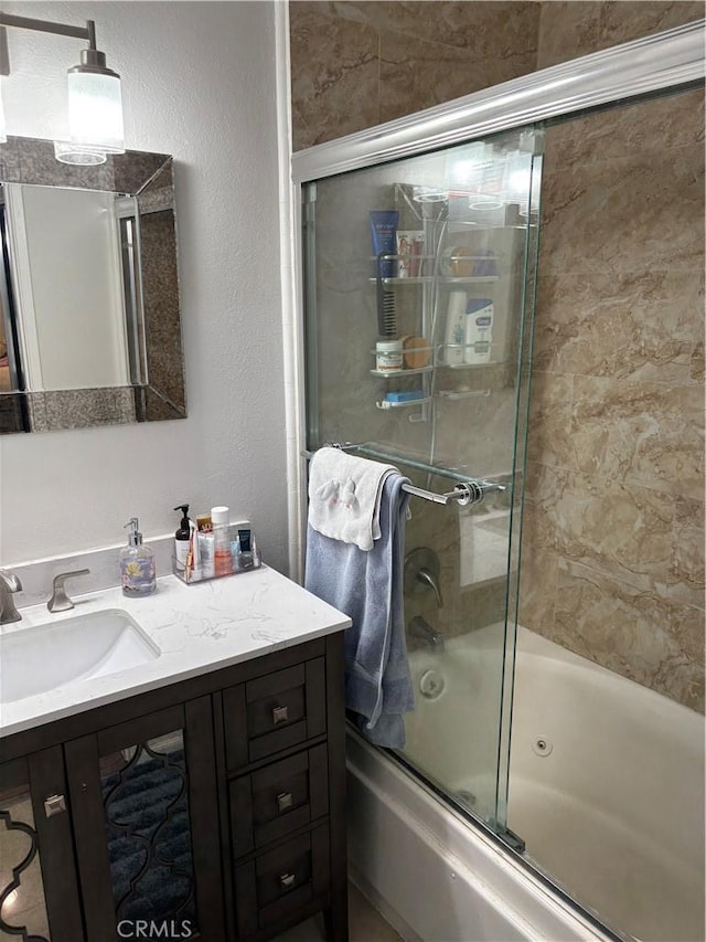 bathroom featuring bath / shower combo with glass door and vanity