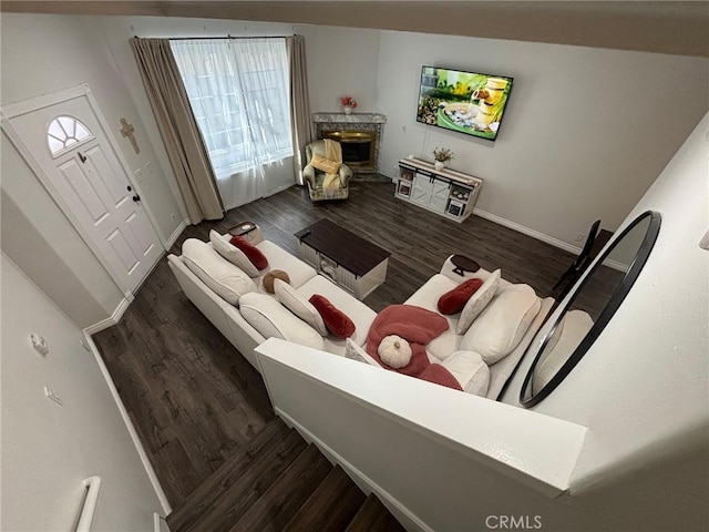 living room with dark wood-type flooring and a healthy amount of sunlight