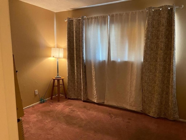 spare room featuring carpet and a textured ceiling