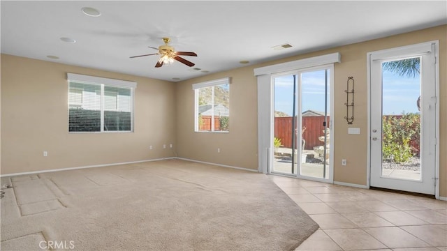 tiled empty room with plenty of natural light and ceiling fan