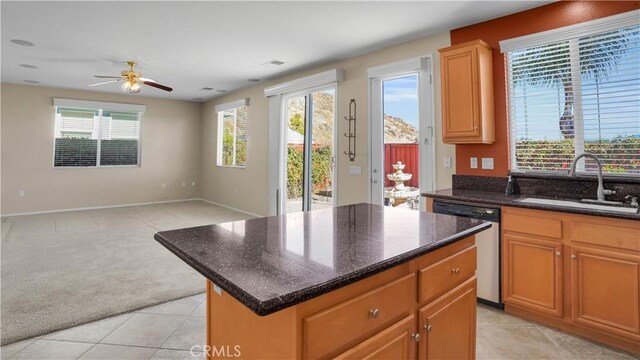 kitchen with sink, light carpet, dishwasher, a kitchen island, and ceiling fan