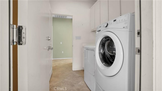 clothes washing area with cabinets, light tile patterned flooring, and washer and clothes dryer