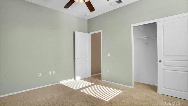 unfurnished bedroom with light colored carpet, a closet, and ceiling fan