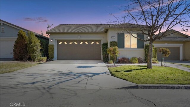 view of front of property featuring a garage and a yard