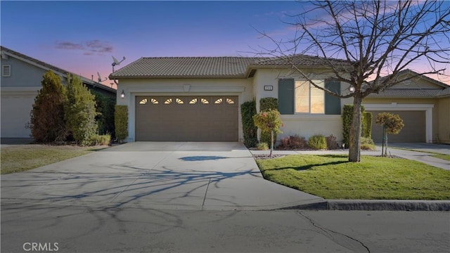 view of front of home featuring a garage and a yard