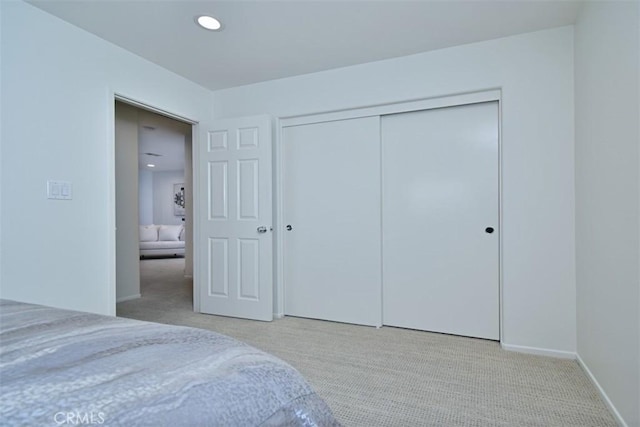 bedroom with light carpet and a closet