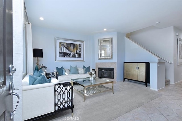 living room featuring a tiled fireplace and light tile patterned flooring