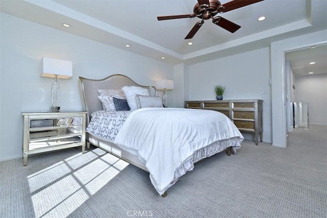 bedroom with ceiling fan, carpet, and a raised ceiling