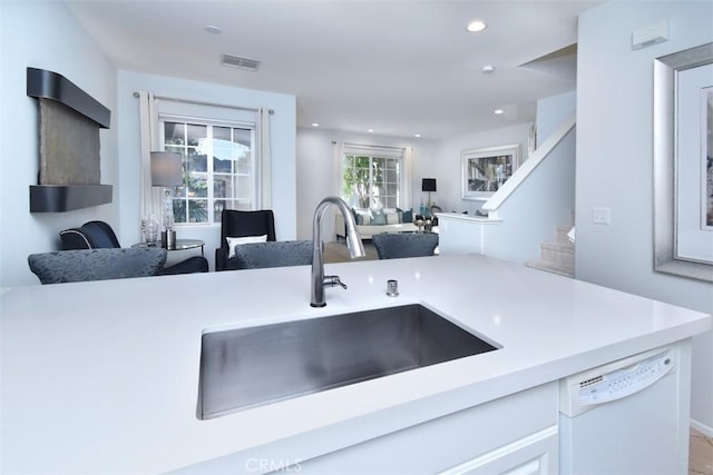 kitchen with white cabinetry, dishwasher, and sink