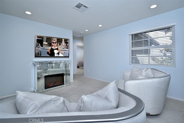 living room featuring light colored carpet and a tiled fireplace