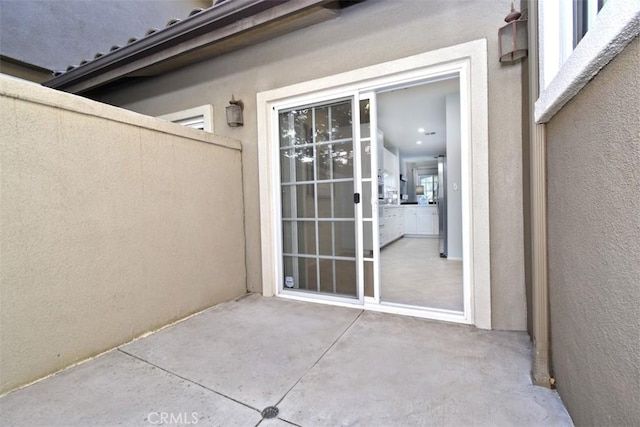 view of exterior entry with a patio