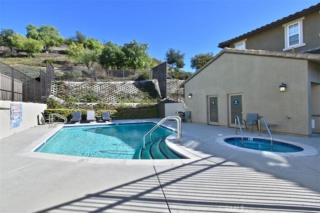 view of pool with a patio area and a hot tub