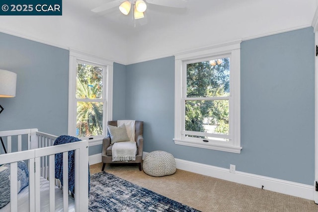 bedroom with ceiling fan, carpet floors, and a crib