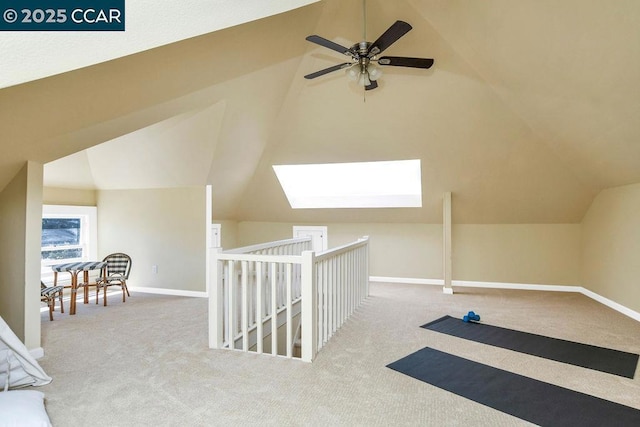 additional living space with ceiling fan, carpet, and lofted ceiling with skylight