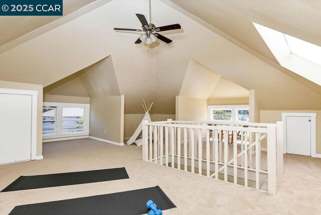 bonus room with light carpet, ceiling fan, and lofted ceiling with skylight