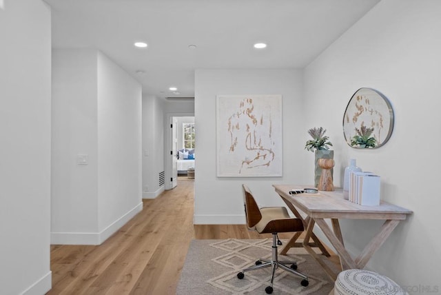 home office with light hardwood / wood-style floors