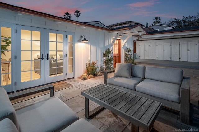 patio terrace at dusk featuring outdoor lounge area and french doors