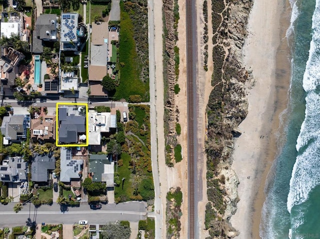 birds eye view of property featuring a beach view and a water view