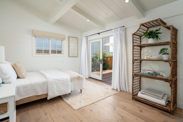 bedroom with light wood-type flooring, vaulted ceiling with beams, and access to outside