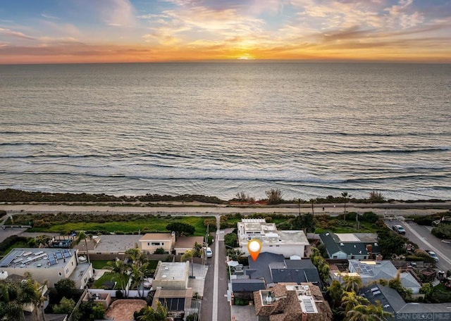 aerial view at dusk featuring a water view