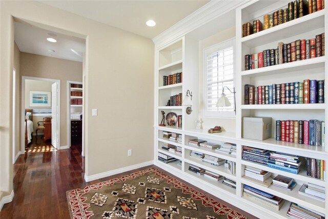 living area featuring dark hardwood / wood-style flooring and built in shelves