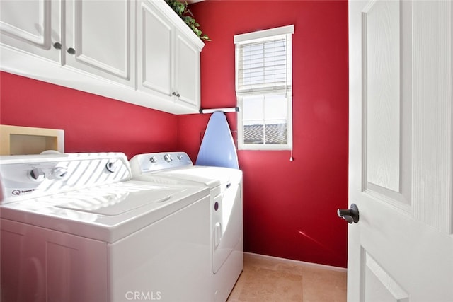 clothes washing area with cabinets and independent washer and dryer