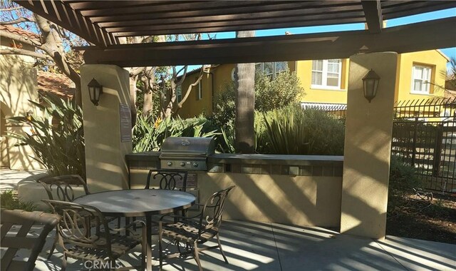 view of patio / terrace featuring a grill, a pergola, and an outdoor kitchen