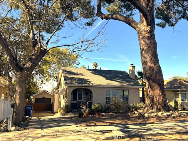 view of front of property featuring a garage and an outdoor structure