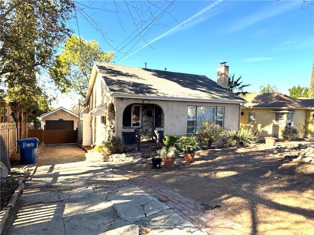 view of front of property with a garage and an outbuilding