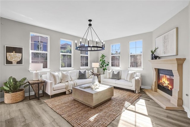 living room featuring a chandelier and light wood-type flooring