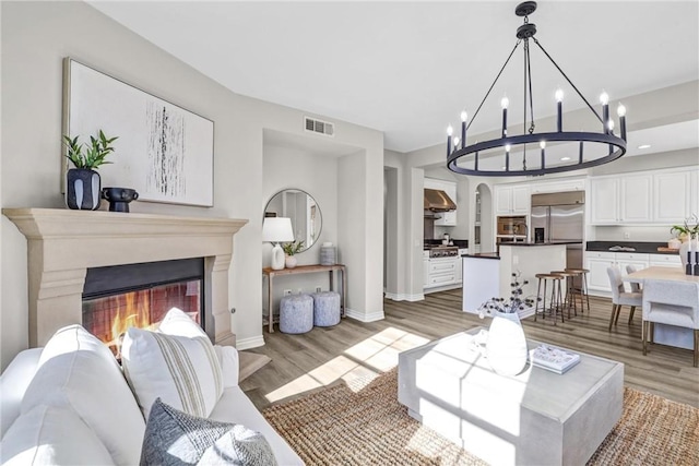 living room featuring a chandelier and light hardwood / wood-style floors