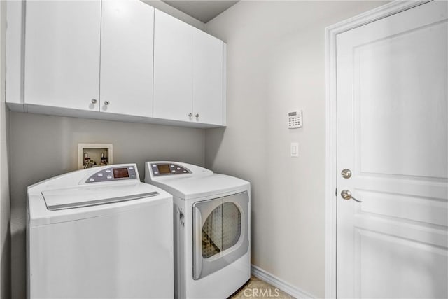 washroom with cabinets and washing machine and clothes dryer