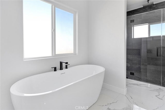 bathroom featuring plenty of natural light and separate shower and tub