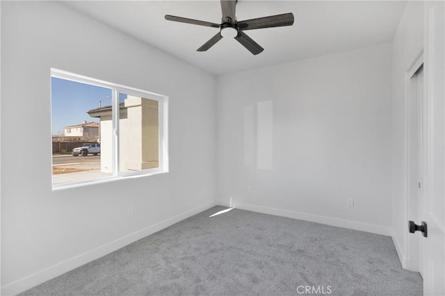 spare room featuring ceiling fan and light colored carpet