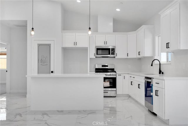 kitchen with white cabinetry, hanging light fixtures, a center island, and stainless steel appliances