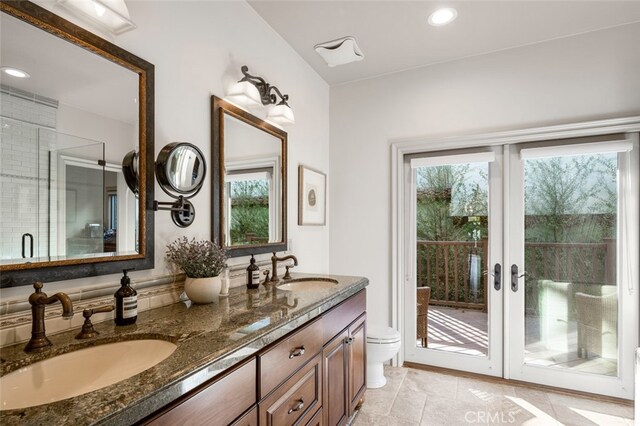 bathroom featuring toilet, vanity, an enclosed shower, and tile patterned flooring