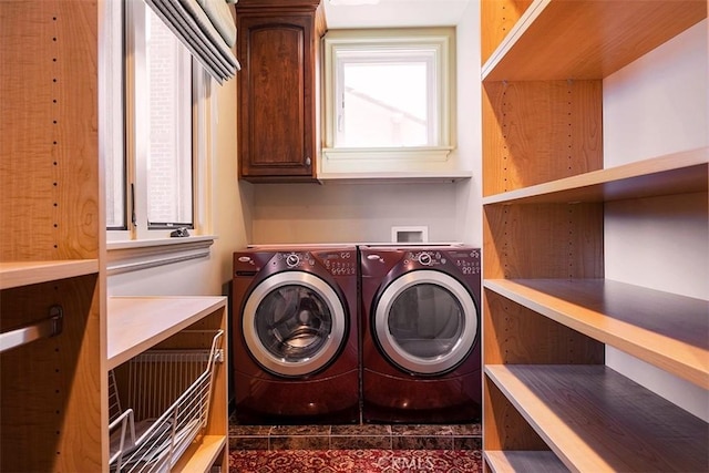 laundry room featuring washer and dryer and cabinets