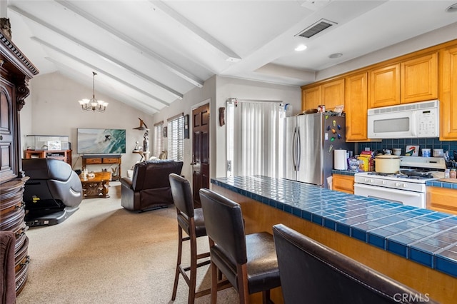 kitchen with light carpet, an inviting chandelier, tile counters, tasteful backsplash, and white appliances